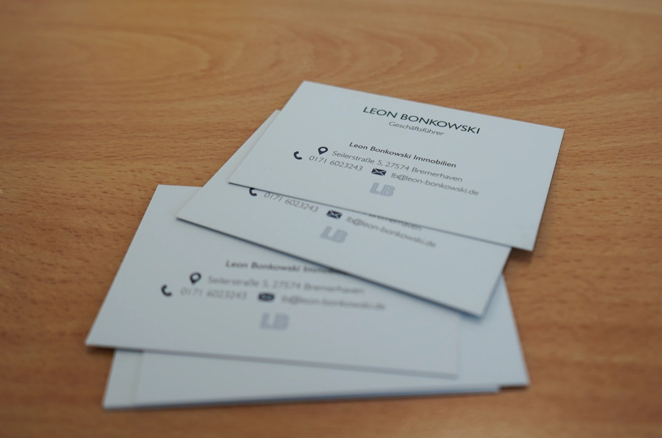 Visitenkarten von Leon Bonkowski Immobilien übereinander gefächert.
